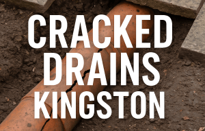 Cracked drain pipe exposed beneath lifted patio slabs in a Kingston home, showing soil erosion and structural damage.