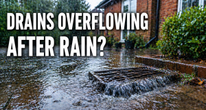 Outdoor drain overflowing during heavy rain at a Kingston property with water pooling on driveway