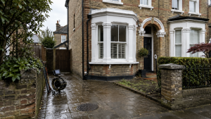 Kingston period home exterior with damp paving, an open inspection chamber and CCTV drain equipment showing older pipework drainage problems.